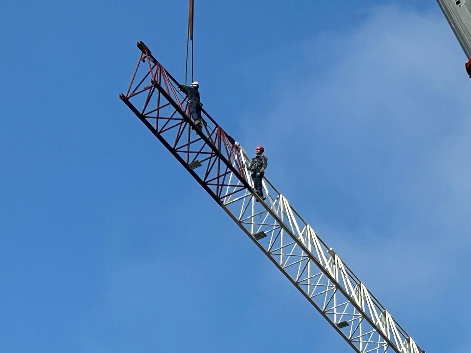 Flèche de grue à tour suspendue dans le ciel pendant le démontage