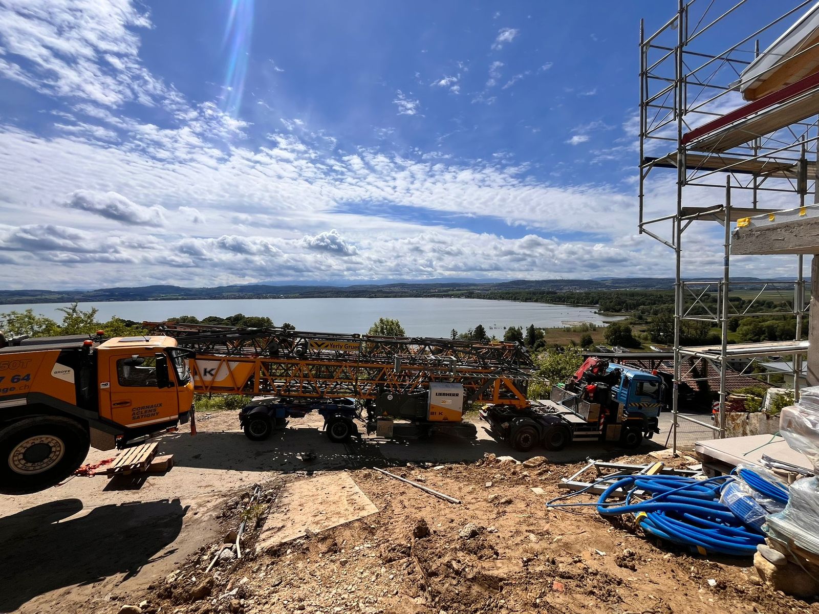 Éléments de la grue à tour posés au sol, le lac en arrière-plan
